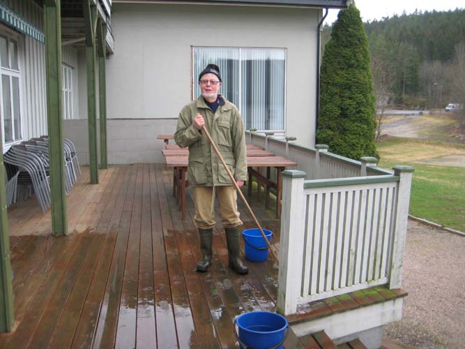 Aage rengjør verandaen foran hovedbygningen